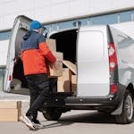 A Man in a Jacket Loading Boxes in a Van